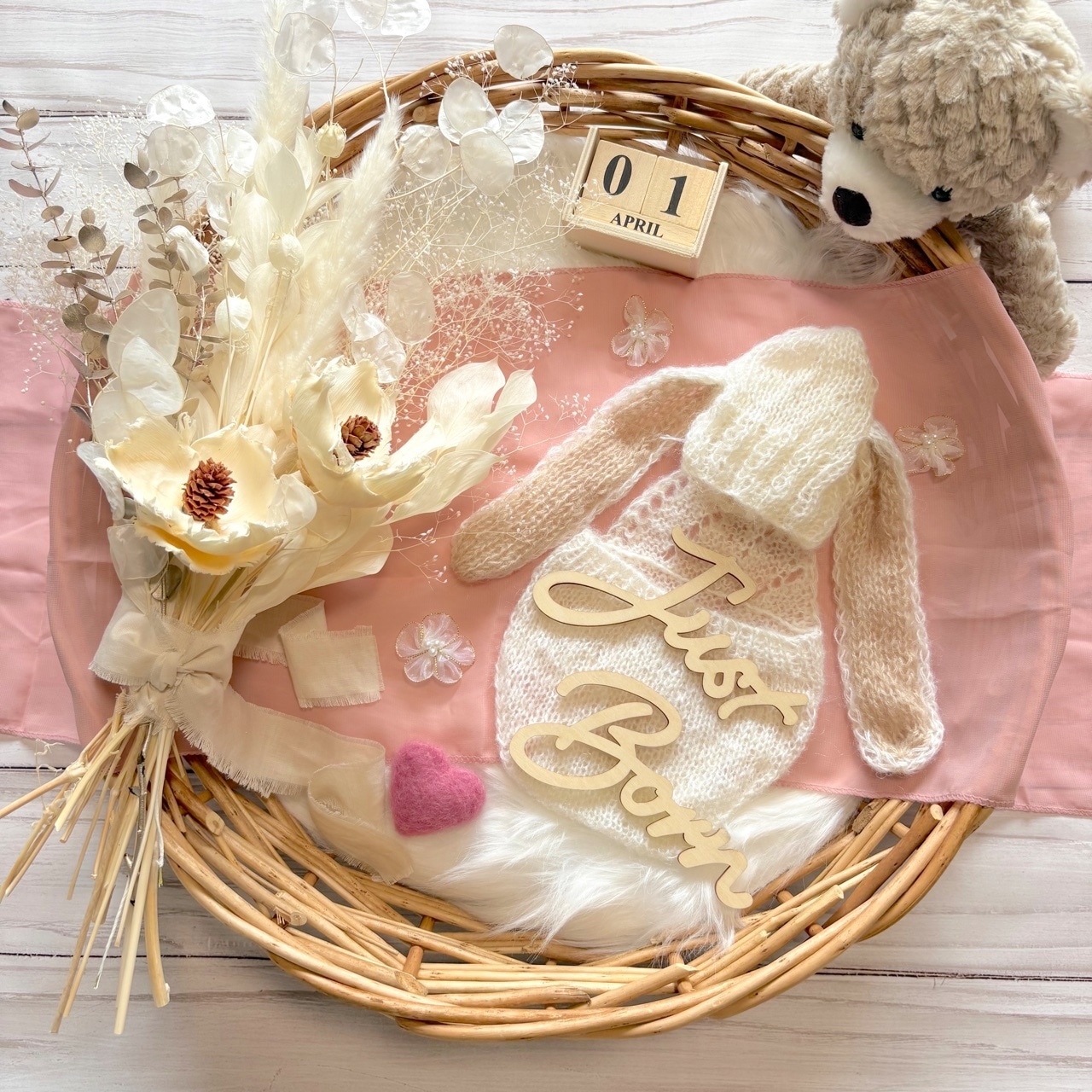 ニューボーンフォト撮影セットとぬいぐるみ、衣装、Just Born プレートを配置した撮影イメージ