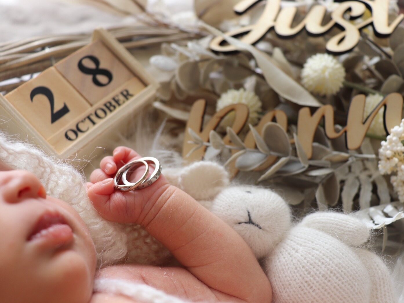 ニューボーンフォト撮影でママとパパの指輪を赤ちゃんが持っている写真