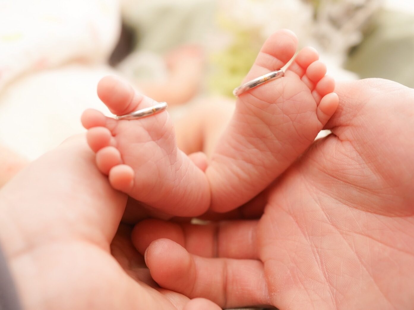 ニューボーンフォト撮影で赤ちゃんの足を支えている構図の写真